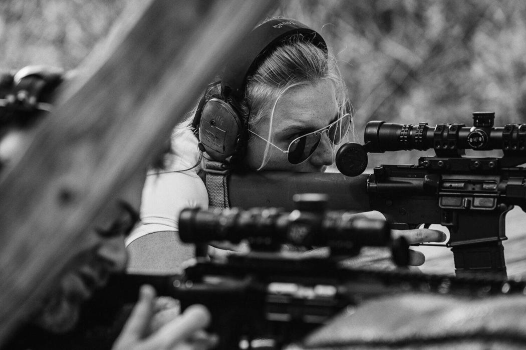 Shooter holding a rifle at the ready on an outdoor range