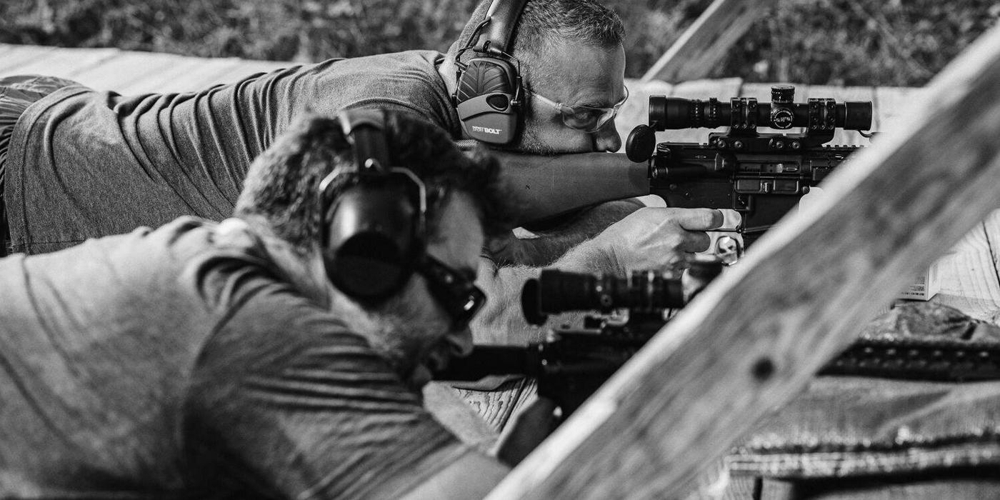 Shooters lined up on the firing line at an outdoor range